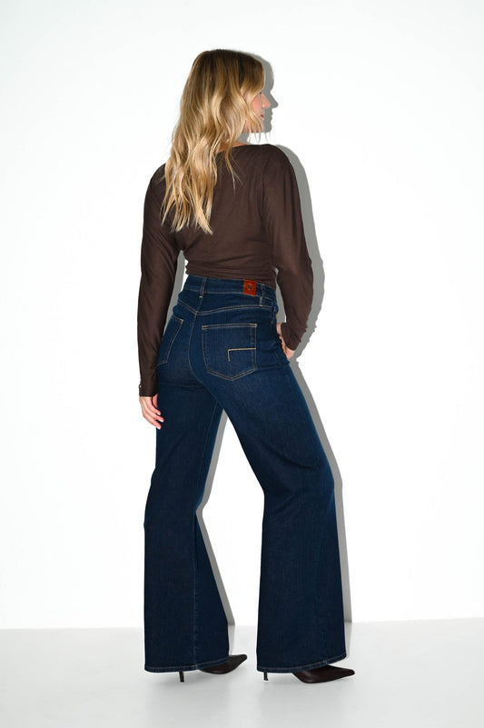 model toont achterzijde van de wide leg jeans francis met donkerblauwe wassing