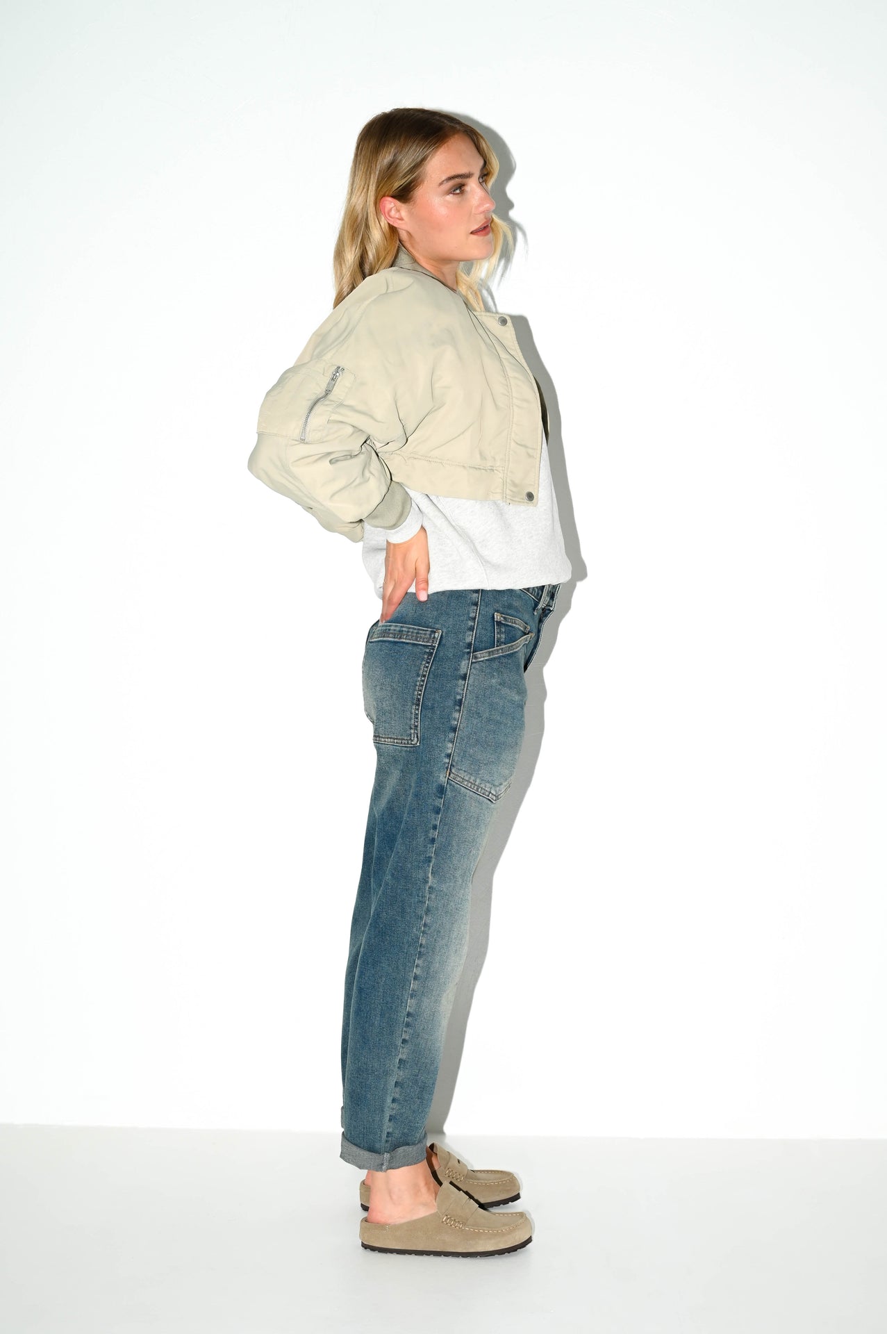 zijaanzicht van carrot fit jeans met een used wassing, stoere zakken en ruime pasvorm rond de bovenbenen
