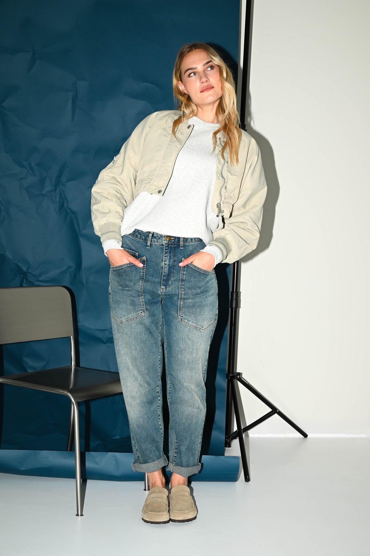 de carrot fit jeans in een grijsblauwe denim gecombineerd met een off white jasje en wit shirt zorgt voor een frisse herfstlook